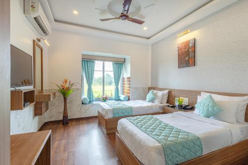 a hotel room with two beds and a television at Salcete Beach Resort in Colva