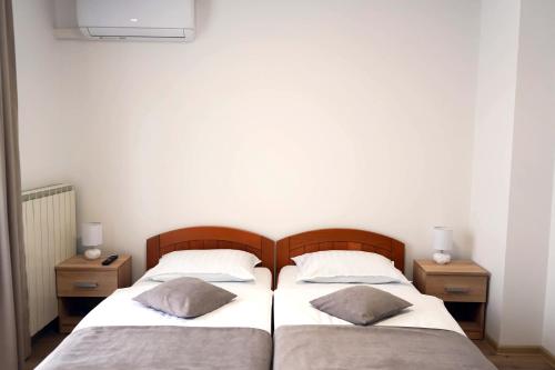 two twin beds in a room with two night stands at Studio Apartman Šafranko in Krapinske Toplice