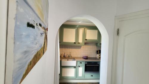 a kitchen with green cabinets and a painting on the wall at Prachtige Vakantiewoning 'la bienvenue' in Venlo, Limburg in Venlo