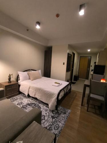 a bedroom with a large bed and a couch at The Serena Suite in Manila