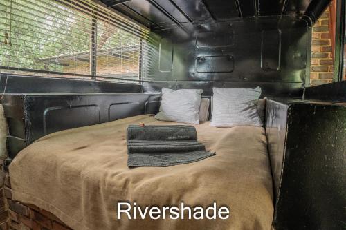 a bed in a trailer with towels on it at Thabela Thabeng in Parys