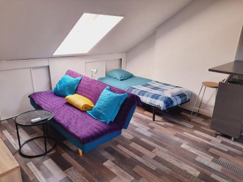 - une chambre avec un canapé violet et un lit dans l'établissement Chez Dogoré, à Reims