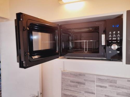 La cuisine est équipée d'un four micro-ondes accroché au mur. dans l'établissement Chez Dogoré, à Reims