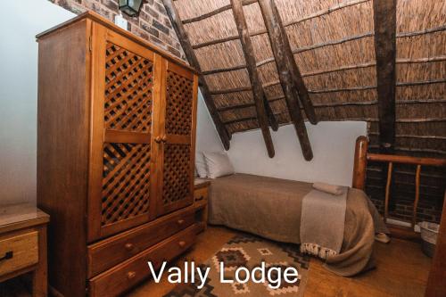 a bedroom with a bed and a wooden cabinet at Thabela Thabeng in Parys