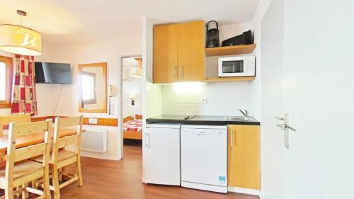 une cuisine avec un réfrigérateur blanc et une table dans l'établissement Résidence Le Cervin - Résidence LE CERVIN N°304 MAE-5551, à La Plagne Tarentaise