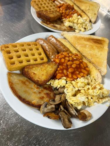 a plate of breakfast food with eggs beans and waffles at Lochway Hotel in Dumbarton