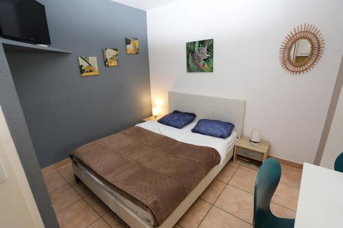 Cette petite chambre comprend un lit avec des oreillers bleus. dans l'établissement Grande studio 2 coeur des animations à 50m plage, à Argelès-sur-Mer