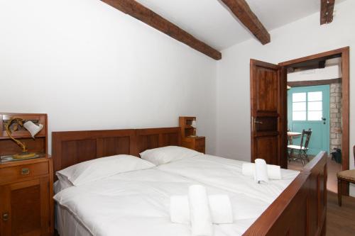 a bedroom with a large white bed with white pillows at Apartments Valentinus 1800 in Sežana
