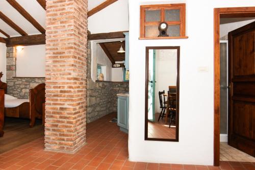 a room with a brick pillar and a mirror at Apartments Valentinus 1800 in Sežana