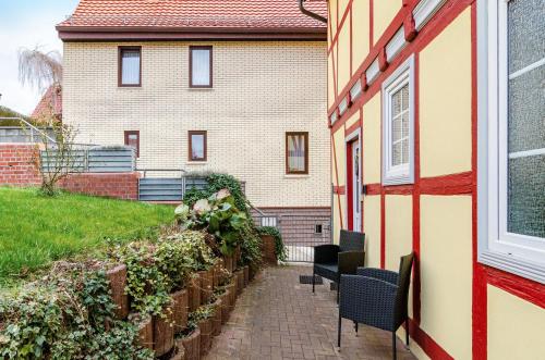 a house with two chairs and a building at Ferienwohnung am West-östlichen Tor in Ecklingerode
