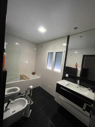 a bathroom with two sinks and a tub and a mirror at Green Pine in Leiria
