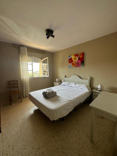 una camera da letto con un letto bianco e un tavolo di Apto dos dormitorios en Ayacosta a Isla Canela