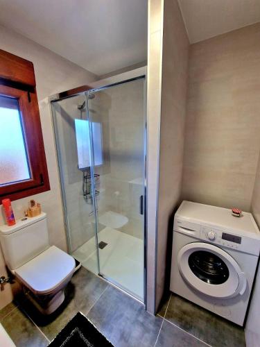 a bathroom with a washing machine and a washer at VV Casa Leonor in Asiego