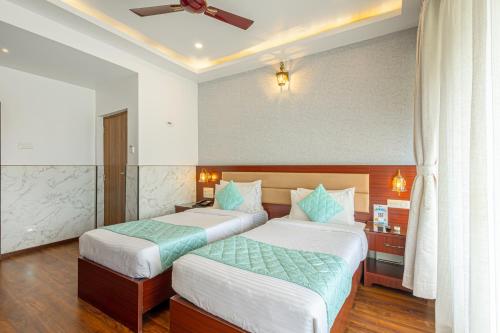 a bedroom with two beds and a ceiling fan at Salcete Beach Resort in Colva