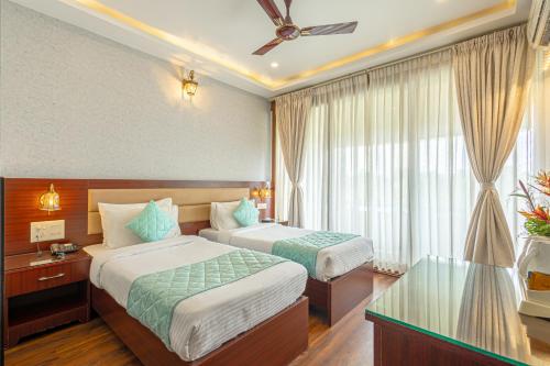 a hotel room with two beds and a window at Salcete Beach Resort in Colva