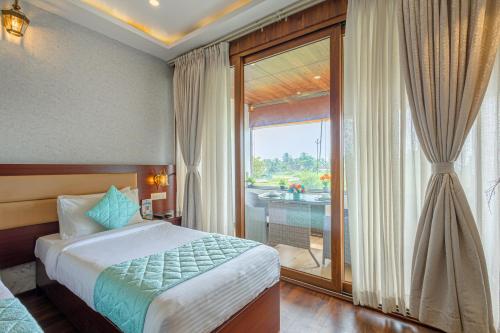 a bedroom with a bed and a large window at Salcete Beach Resort in Colva