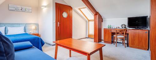 a hotel room with a bed and a table and a couch at Columbus Rowy in Rowy