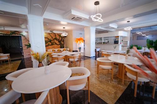a restaurant with white tables and white chairs at Hotel Almar Luxury in Mamaia Nord