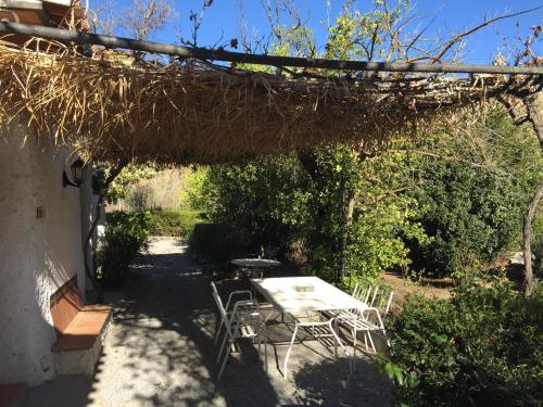 a table and chairs sitting under a pergola at Casas Cueva y Cortijo La Tala en Guadix in Guadix