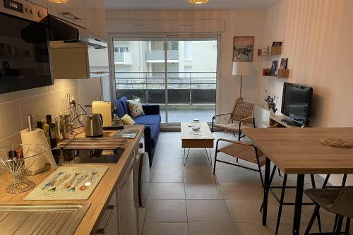 une cuisine et un salon avec un canapé et une table dans l'établissement Cozy T2 with balcony near the sea, à Saint-Malo
