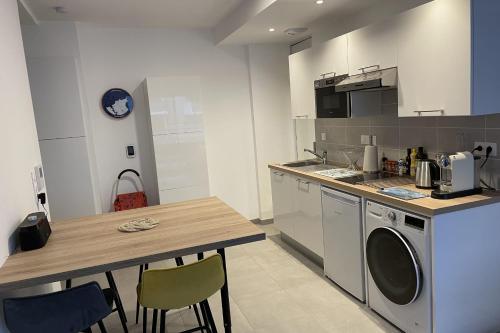 une cuisine avec un comptoir et une table avec des chaises dans l'établissement Cozy T2 with balcony near the sea, à Saint-Malo