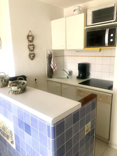 - une cuisine avec du carrelage bleu sur le comptoir et un four micro-ondes dans l'établissement Apartment with terrace in Cavalaire-sur-Mer, à Cavalaire-sur-Mer