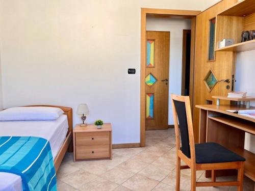 a bedroom with a bed and a desk and a chair at The Front Beach Penthouse 20 m by Salento Prime in Marina di Pescoluse