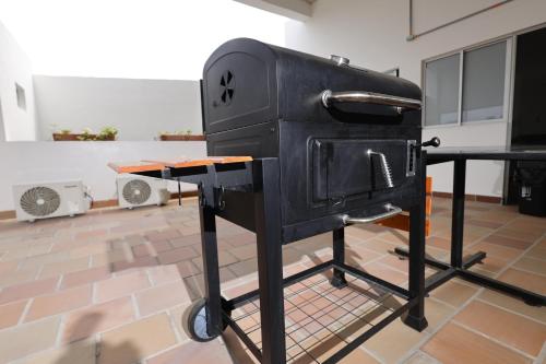a black stove in a room with a table at Hotel Astor Cucuta in Cúcuta