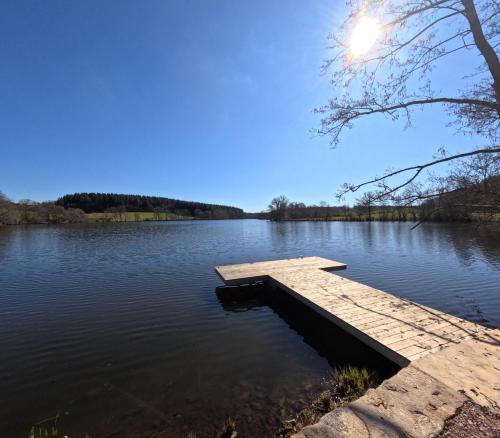 un quai au milieu d'un lac dans l'établissement L'Ancien Moulin du Château de Marrault - Gîte de groupe, à Magny