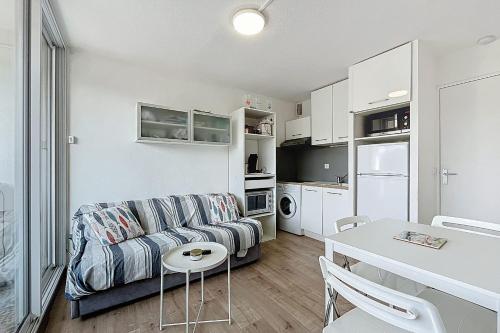 un salon avec un canapé et une table dans l'établissement Le Cordier - Apartment near the harbor, à Gruissan