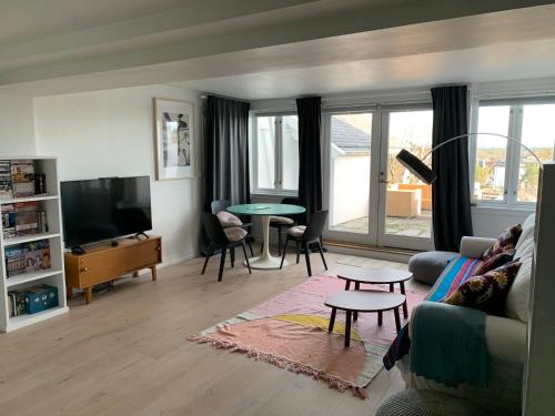 a living room with a couch and a table at Fantastic apartment with garden and sea view on Bygdøy in Oslo