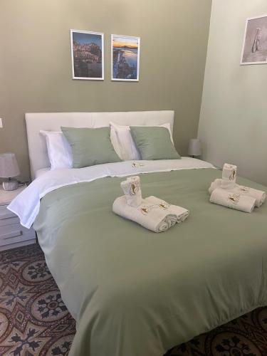 a large green bed with towels on top of it at Affittacamere Stella Rooms in Reggio Calabria
