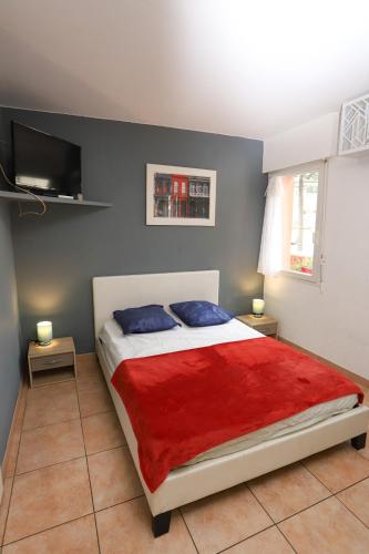 une chambre avec un grand lit avec une couverture rouge dans l'établissement Grand studio 3 50m de la plage, à Argelès-sur-Mer