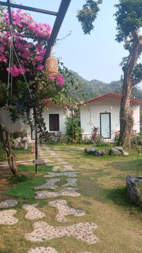 a garden with pink flowers and a building at Tran Chau Garden Home in Cat Ba
