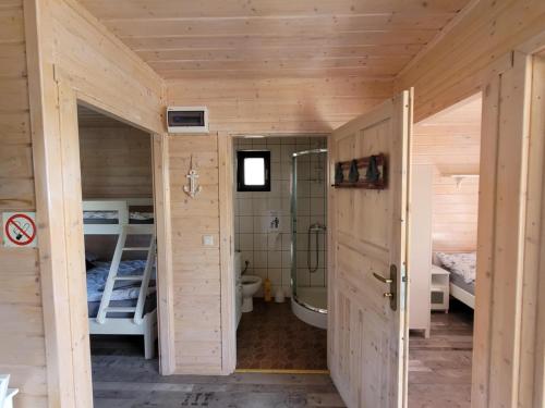 a wooden cabin with a bathroom and a bedroom at Białe Domki in Sarbinowo
