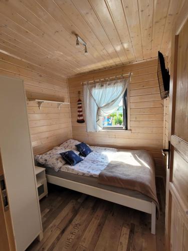 a bedroom with a bed in a wooden cabin at Białe Domki in Sarbinowo