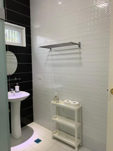 une salle de bain avec un lavabo, des toilettes et une douche dans l'établissement Oville Tagaytay- Cozy and Senior Friendly House, à Tagaytay