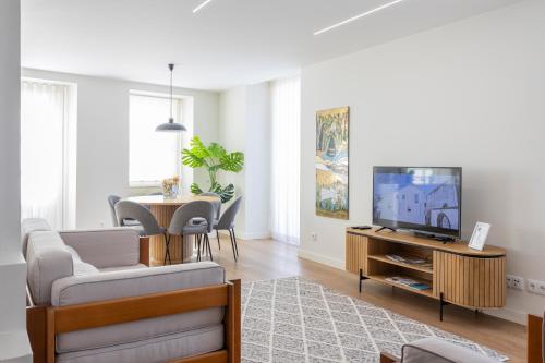 a living room with a couch and a tv and a table at Mexia Galvão city center in Viana do Castelo