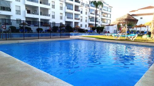 een blauw zwembad voor een gebouw bij La Cala Mijas Cozy Apartment in La Cala de Mijas