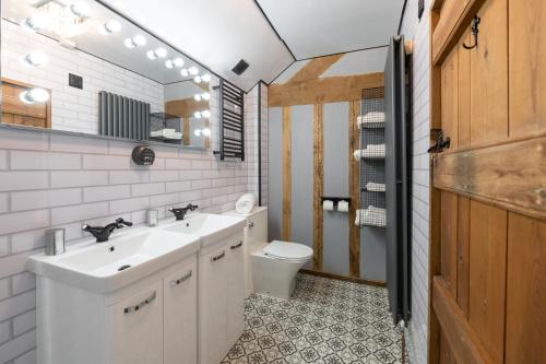 a bathroom with two sinks and a toilet at Cosy 2 bedroom apartment, terrace with Hot Tub 8am - 10pm plus private daily use of indoor pool and sauna 1 hour in Stanton in Peak