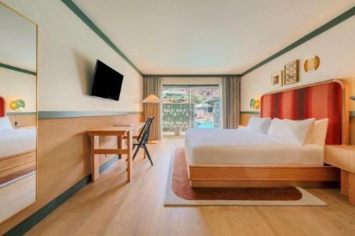 a hotel room with a bed and a desk at Royal Sun Palm Springs in Palm Springs