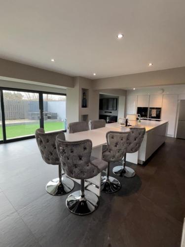 a kitchen with a table and chairs in a room at Large Modern Family Home in Murrayfield - Very close to City Centre - 10 mins by Direct Bus - Private Driveway & Garden in Edinburgh