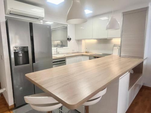 a kitchen with a wooden counter top and a refrigerator at Apartamento Levante Playa Torretjó in Benidorm