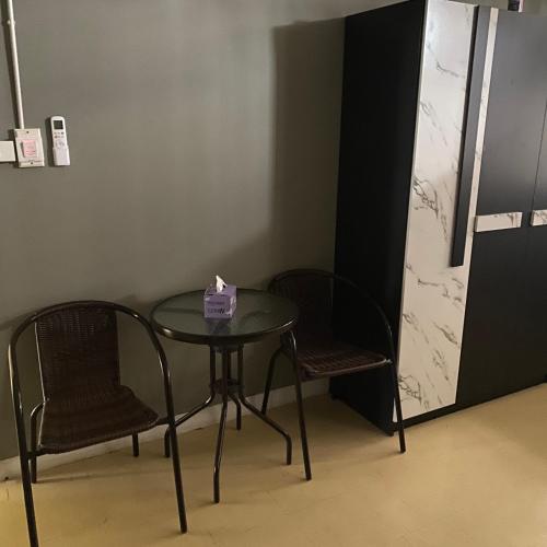 a table and two chairs and a table with a box on it at New Saran Hostel krabi in Krabi town