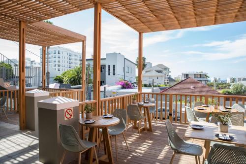 Un restaurante con mesas y sillas en una terraza. en Antrim House by Totalstay, en Ciudad del Cabo
