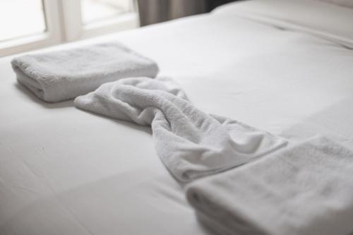 a white bed with two towels on top of it at Modern1-Bed - Central Croydon in South Norwood