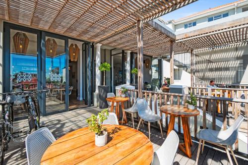 a patio with tables and chairs on a balcony at Antrim House by Totalstay in Cape Town