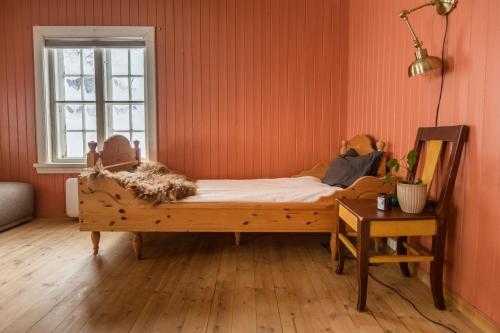 LøkenExperience Jotunheimen from Vevstogo - sauna with a view and eco living in an old school building的橙色墙壁和窗户的房间里一张床位