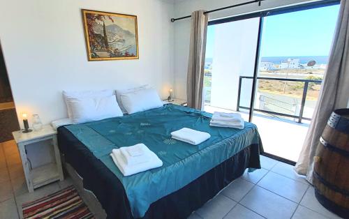 a bedroom with a bed with two towels on it at Columbine Views in Stompneusbaai