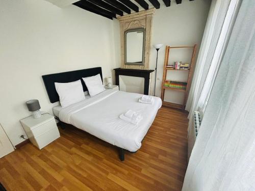 une chambre avec un lit blanc et un miroir dans l'établissement Appartement spacieux de charme en hyper-centre, à Caen